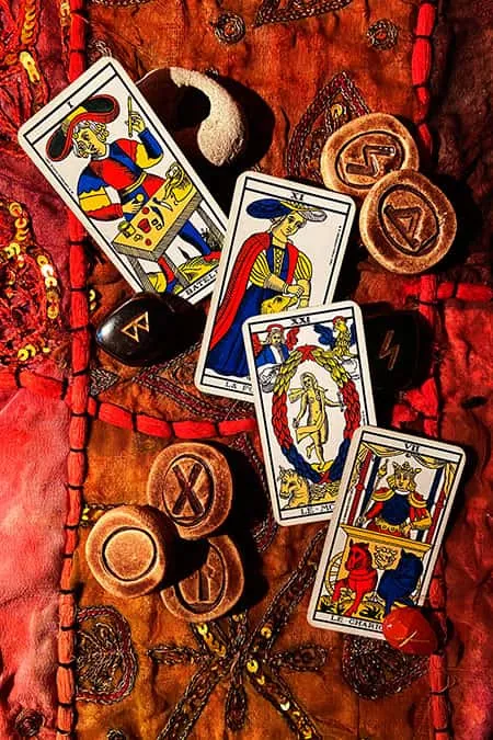 Cartas del tarot de Marsella y runas sobre tela roja