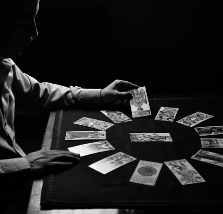 Vidente colocando las cartas en círculo sobre un tapete negro