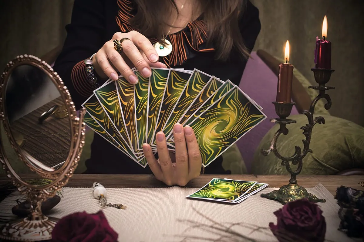 Manos abriendo en abanico un mazo de cartas del tarot